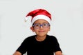 6 year old dark latino boy is ready to celebrate the holidays and write his letter to Santa Claus with Christmas hat