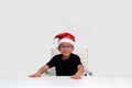 6 year old dark latino boy is ready to celebrate the holidays and write his letter to Santa Claus with Christmas hat