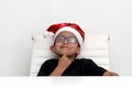 6 year old dark latino boy is ready to celebrate the holidays and write his letter to Santa Claus with Christmas hat