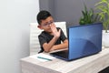 Boy does home schooling takes online classes at home on a desk with a laptop, studies, is surprised and participates in class