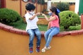 6-year-old Latino boys couple with face masks sitting waiting to play in times of covid-19