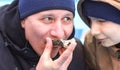 A 45-year-old man tries a live oyster for the first time. Nearby, the son curiously observes his father's reaction