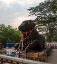 350 year old monolithic statue of Nandi (Bull) with temple priest, Chamundi Hill, Mysore, India.