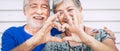 70 year old senior couple playing forming heart with hands. Happiness and joy together forever concept for old people man and Royalty Free Stock Photo