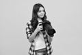 12, 13, 14 year old teen girl holding digital camera or DSLR over yellow background. Royalty Free Stock Photo