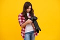 12, 13, 14 year old teen girl holding digital camera or DSLR over yellow background. Royalty Free Stock Photo