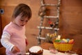 Toddler girl concentrated on decorating Orthodox Easter cake with eggwhite whip Royalty Free Stock Photo