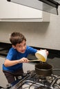 8 year old using a spatula to pour condensed milk into the pan and smiling