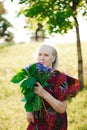 80 year old woman with a bouquet of flowers in her hands. Royalty Free Stock Photo