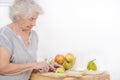 A 80 year old woman cutting apples in kitchen Royalty Free Stock Photo