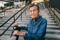 90 year old woman with gray hair, wrinkles, progressive and active uses modern electric transport scooter. Lady Royalty Free Stock Photo