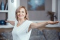 A 50 Year Old Woman Practices Yoga at Home in the Living Room.