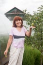 60-year-old woman takes care of   young fruit tree Royalty Free Stock Photo