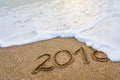 The year 2018 passed the concept. The wave of foam washes away the inscription 2018 written on the sand