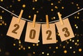 The year 2023 on pinned cards hanging from a string. Bookeh background