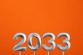 Year 2033 - Silver number on orange foamy background