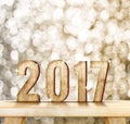 2017 year wood number on wood table with gold sparkling bokeh wa