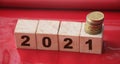 Year 2021 on wooden cubes and stack of coins. economy growth and recovery, increase money saving and investment concept Royalty Free Stock Photo