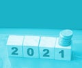 Year 2021 on wooden cubes and stack of coins. economy growth and recovery, increase money saving and investment concept Royalty Free Stock Photo