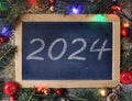 year 2024 written on a chalk slate surrounded by Christmas decorations Royalty Free Stock Photo
