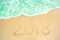 Year 2018 written at the sand beach with sea wave water. wave coming to 2018 concept on the sand beach in the morning Royalty Free Stock Photo