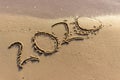 The year 2020 is written on the sandy shore. 2020 comes to an end and is washed away by the wave. Summer background Royalty Free Stock Photo