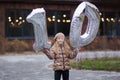 10 years birthday. the girl is holding large silver numbers one and zero. Cute joyful birthday girl with balloons Royalty Free Stock Photo