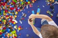 4 years boy building a tower with with interlocking plastic bricks game