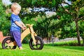 2 - 3 years joyful child riding a wooden balance bike Royalty Free Stock Photo