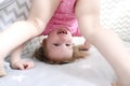 2 years little girl stands on head in wigwam tent