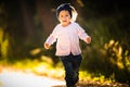 2 years old baby girl running in forest towards camera. with happy expression on her face Royalty Free Stock Photo