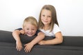 7 years old beautiful little girl posing happy at home sofa couch with her small cute young 3 years old brother in siblings love r Royalty Free Stock Photo