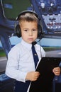 4 years old boy in a pilot suit posing inside the plane