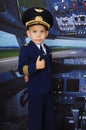 4 years old boy in a pilot suit posing inside the plane