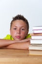 12 years old boy sitting at the table with books