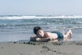 13 years old boy relaxation on the sand on the beach in the sea waves. Concept of family summer vacation Royalty Free Stock Photo