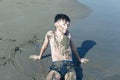 13 years old boy relaxation on the sand on the beach in the sea waves. Concept of family summer vacation Royalty Free Stock Photo