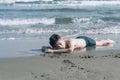 13 years old boy relaxation on the sand on the beach in the sea waves. Concept of family summer vacation Royalty Free Stock Photo