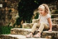 5 years old child girl sitting on old stone stairs Royalty Free Stock Photo