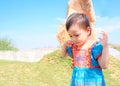 3 years old cute baby Asian girl looking down to floor on blue sky background Royalty Free Stock Photo