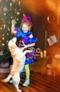 4 years old girl in blue carnival costume of clown play with dog near christmas tree. Happy christmas and new year. Friendship Royalty Free Stock Photo