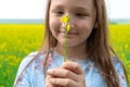 9 years old girl holding a yellow flower in the field. Disfocus