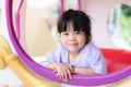 A 3-4 years old girl is playing in an amusement park. The child looked out of the window. Children smiles sweet and bright.