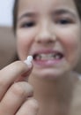 9 years old girl showing her first canine tooth fallen out