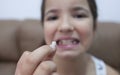 9 years old girl showing her first canine tooth fallen out