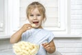 Child eating corn sticks at the kitchen table Royalty Free Stock Photo