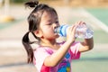 A 3-4 years old girl was drinking water to quench her thirst due to the hot weather. Kid sweat on their faces.