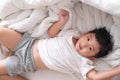 3 years old little cute Asian boy at home on the bed, kid lying Royalty Free Stock Photo