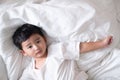 3 years old little sick or illness Asian boy at home on the bed, sad kid laying resting on white bed with pillow and blanket, top Royalty Free Stock Photo