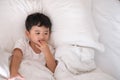 3 years old little sick or illness Asian boy at home on the bed, sad kid laying resting on white bed with pillow and blanket, top Royalty Free Stock Photo
